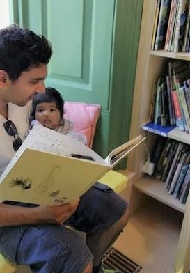 Ella being read to by her father Jason
